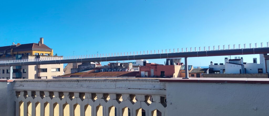 sistema de muelles antipalomas SMAPI transparente en barandilla con bridas